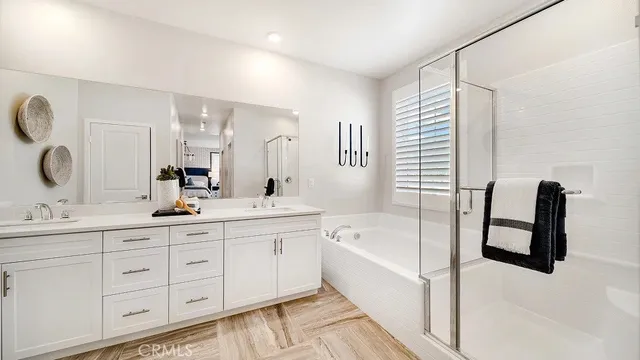 a spacious bathroom with a double vanity sink a mirror and a bathtub