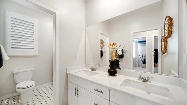 a bathroom with a sink a toilet and a mirror