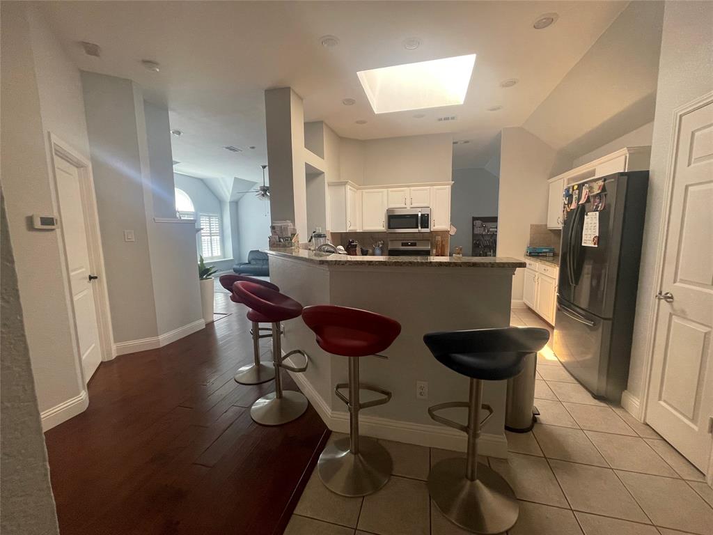 7916 Country Ridge Lane Plano, TX 75024 - Photo 27 of 27 a kitchen with stainless steel appliances a dining table chairs and refrigerator