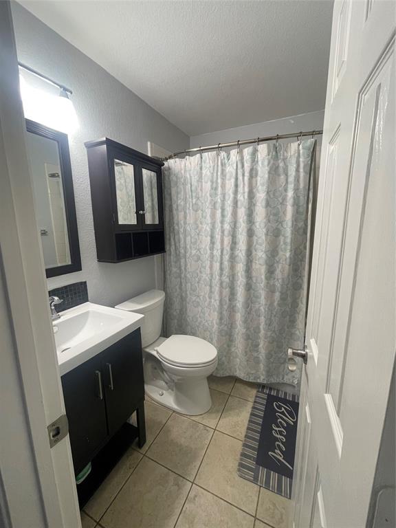 7916 Country Ridge Lane Plano, TX 75024 - Photo 4 of 27 a bathroom with a toilet a sink and a mirror
