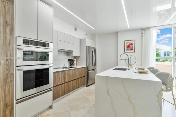a kitchen with stainless steel appliances kitchen island a table and chairs