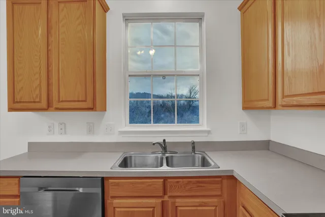 a kitchen with stainless steel appliances granite countertop white cabinets sink and dishwasher with wooden floor