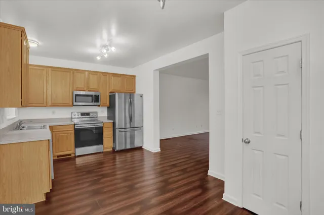 a kitchen with wooden floors and white appliances