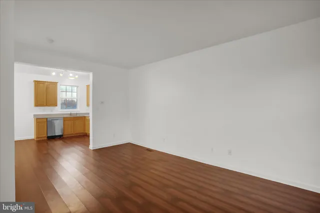 a view of a room with wooden floor and white walls