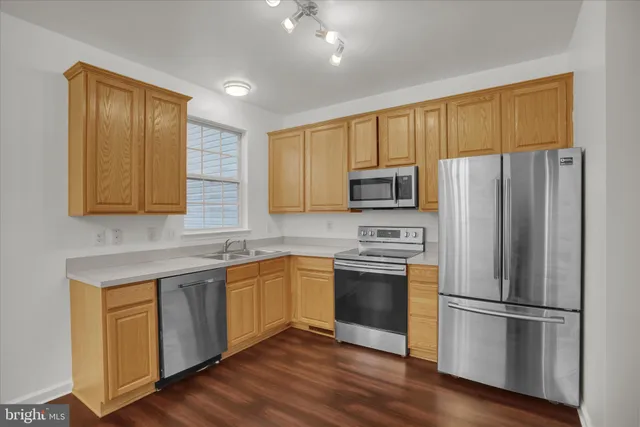 a kitchen with stainless steel appliances granite countertop a refrigerator stove microwave and sink