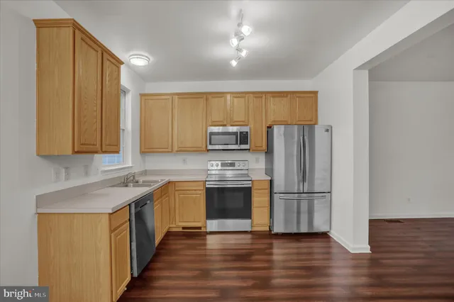 a kitchen with wooden cabinets and stainless steel appliances