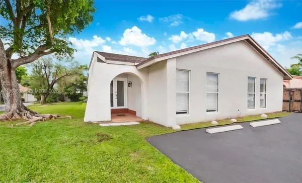 a front view of a house with yard and green space