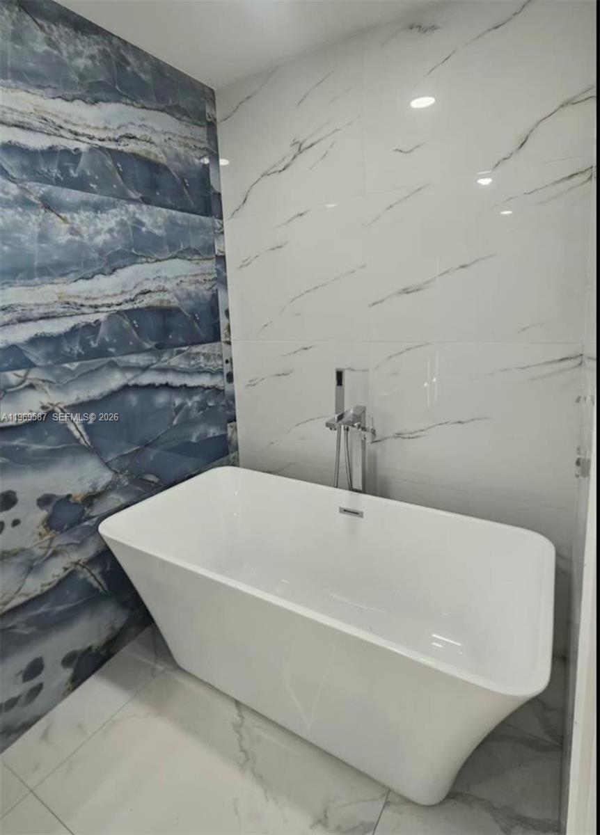 11417 Southwest 35th Lane Miami, FL 33165 - Photo 18 of 18 a white bath tub sitting in a bathroom