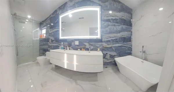 a bathroom with a double vanity sink toilet and shower