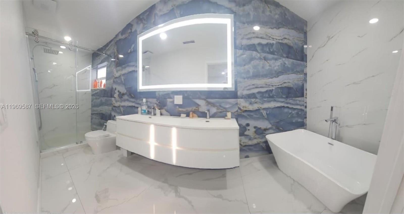 11417 Southwest 35th Lane Miami, FL 33165 - Photo 4 of 18 a bathroom with a white tub shower and sink