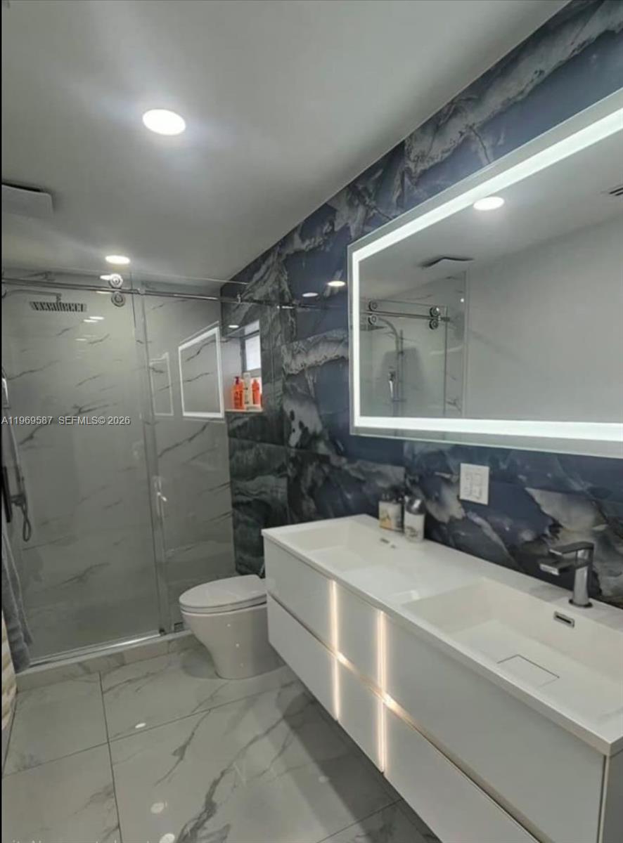 11417 Southwest 35th Lane Miami, FL 33165 - Photo 5 of 18 a bathroom with a double vanity sink toilet and shower
