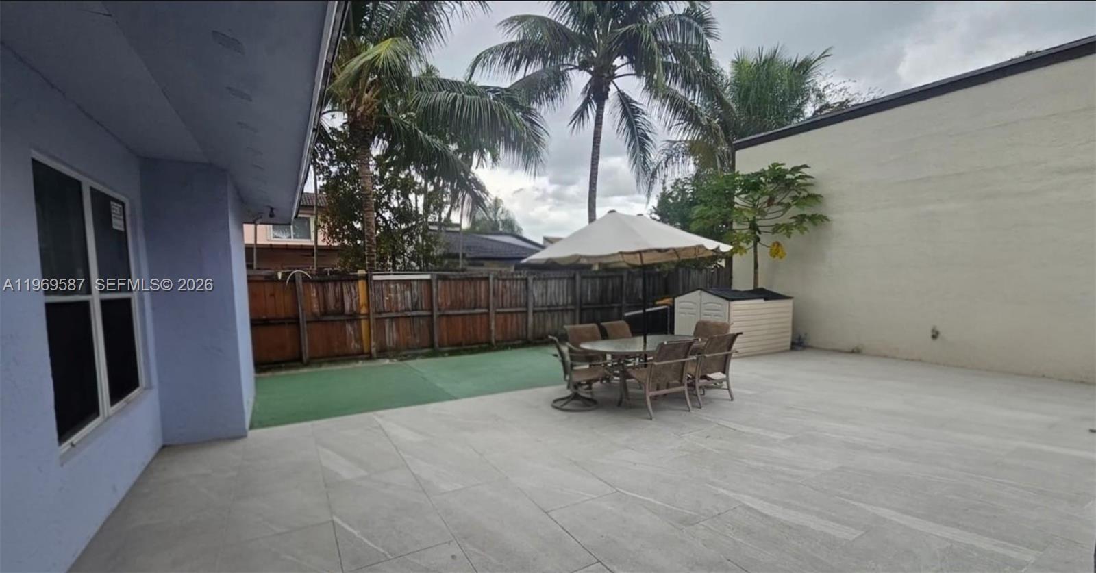 11417 Southwest 35th Lane Miami, FL 33165 - Photo 6 of 18 a view of a patio with table and chairs potted plants and palm tree