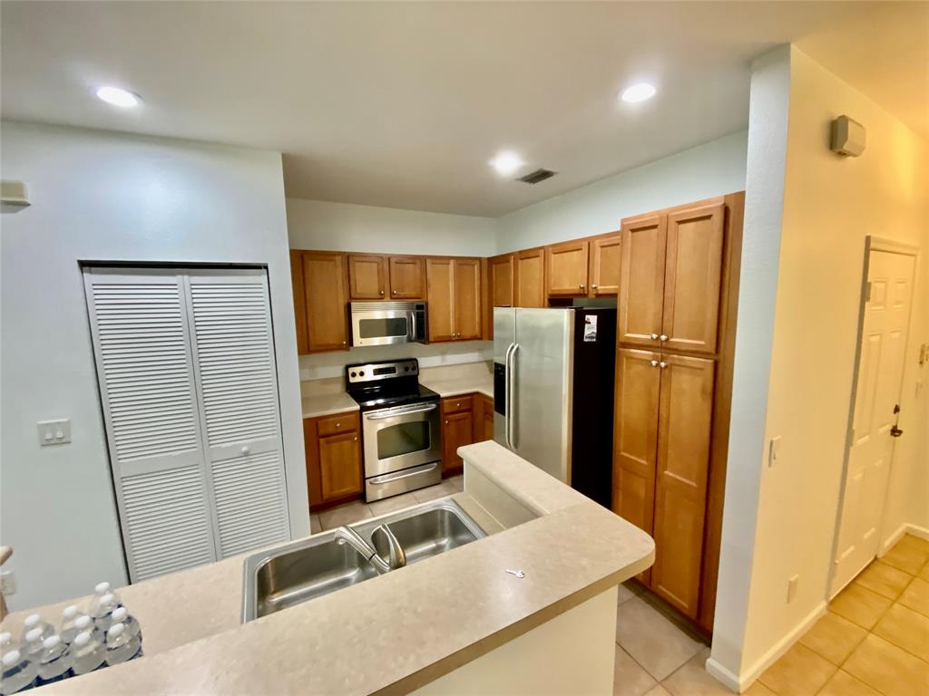 8720 Cypress Walk Court, Unit 8720 Tamarac, FL 33321 - Photo 18 of 36 a kitchen with stainless steel appliances granite countertop a refrigerator stove and sink