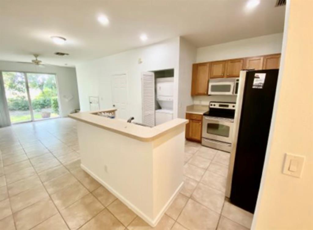 8720 Cypress Walk Court, Unit 8720 Tamarac, FL 33321 - Photo 3 of 36 a large white kitchen with a sink stainless steel appliances and cabinets