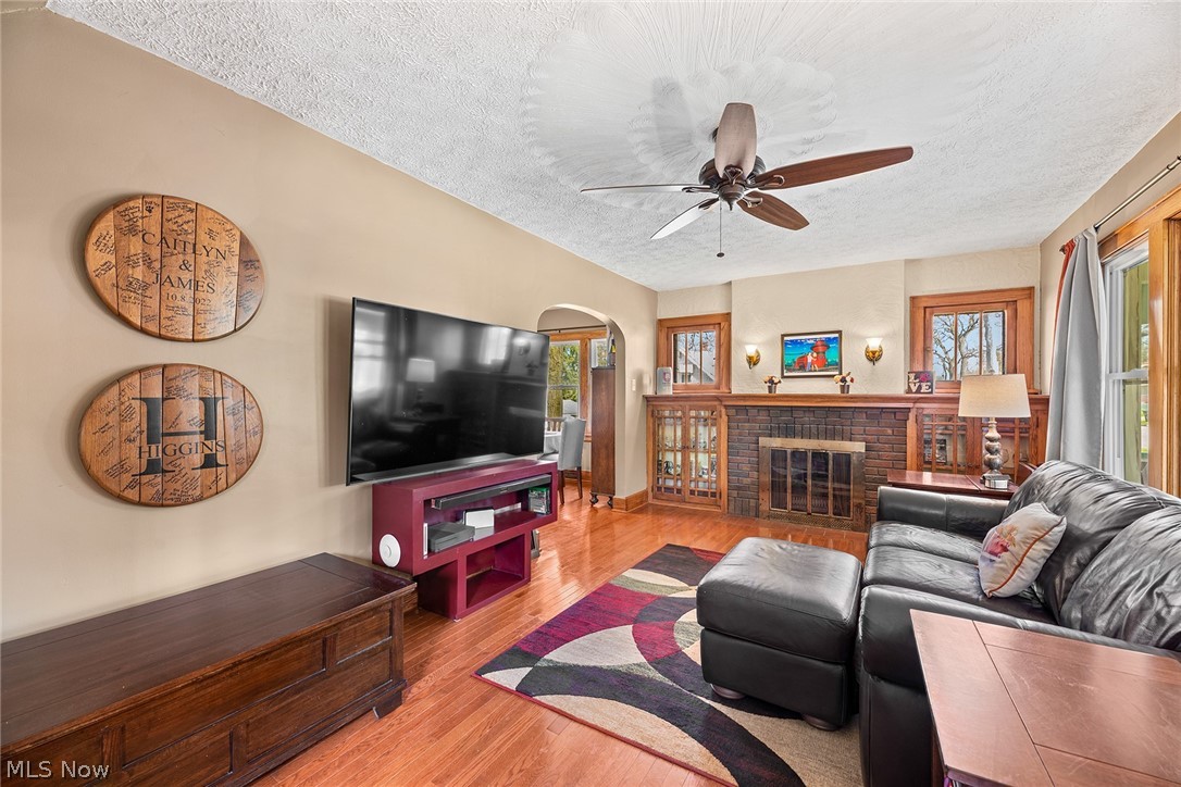 382 Baldwin Road Akron, OH 44312 - Photo 4 of 35 Living room with light hardwood / wood-style floors, a brick fireplace, ceiling fan, and a wealth of natural light