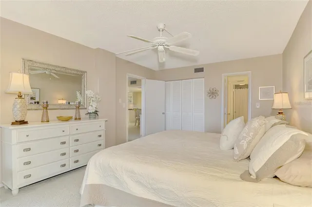 a bedroom with a bed a chandelier and a mirror on dresser