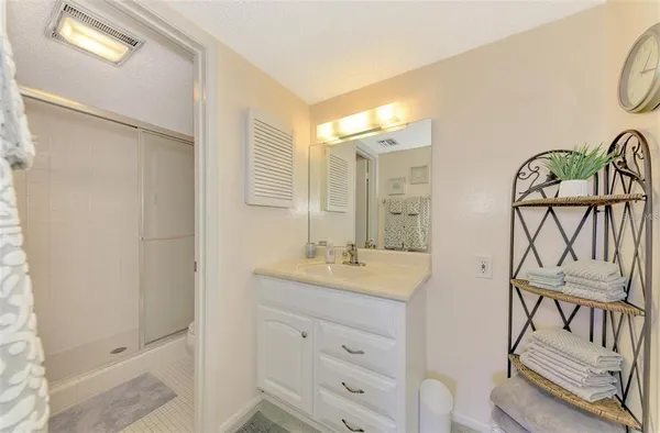 a bathroom with a granite countertop sink a mirror and a shower