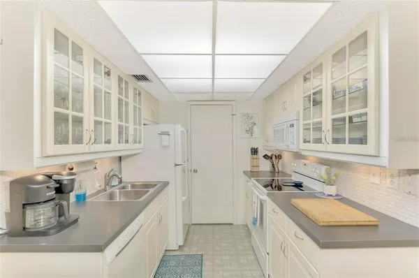 a kitchen with granite countertop a sink and a stove top oven