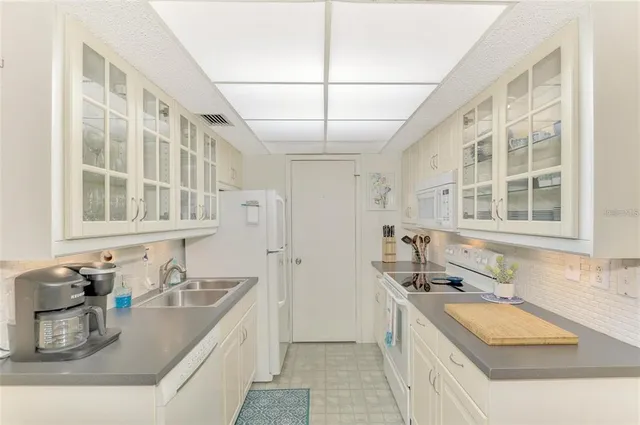 a kitchen with granite countertop a sink and a stove top oven