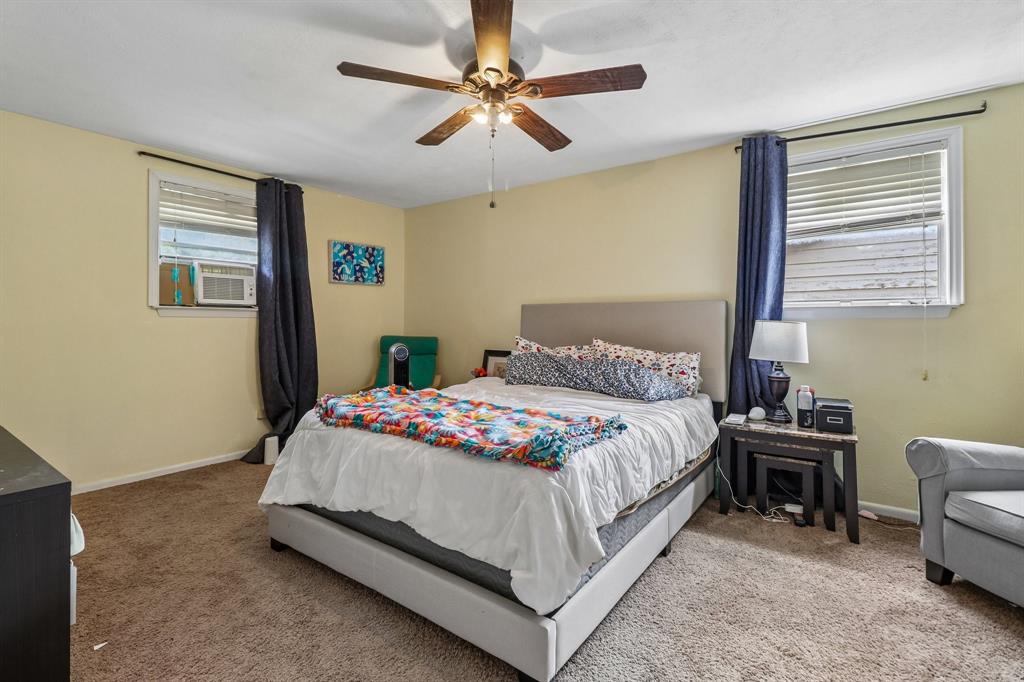 820 North Bowen Road Arlington, TX 76012 - Photo 29 of 40 a bedroom with a bed a couch and a chandelier