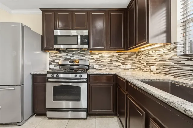 a kitchen with granite countertop a stove microwave and sink