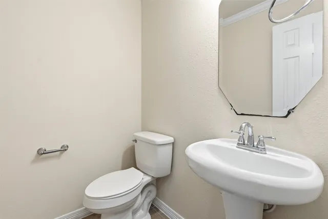 a bathroom with a sink toilet and mirror
