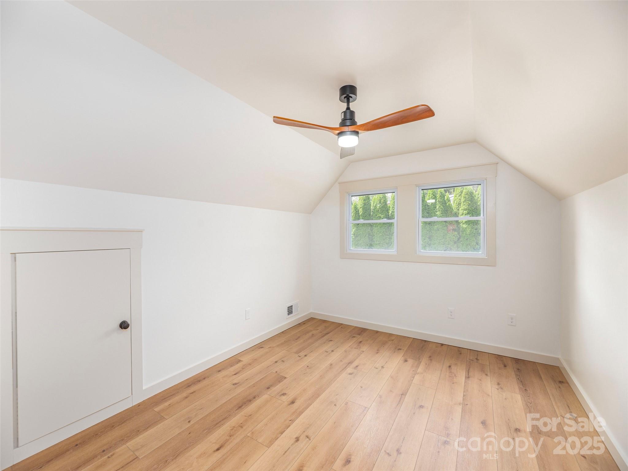 93 Cresthaven Drive Clyde, NC 28721 - Photo 20 of 27 an empty room with wooden floor ceiling fan and windows