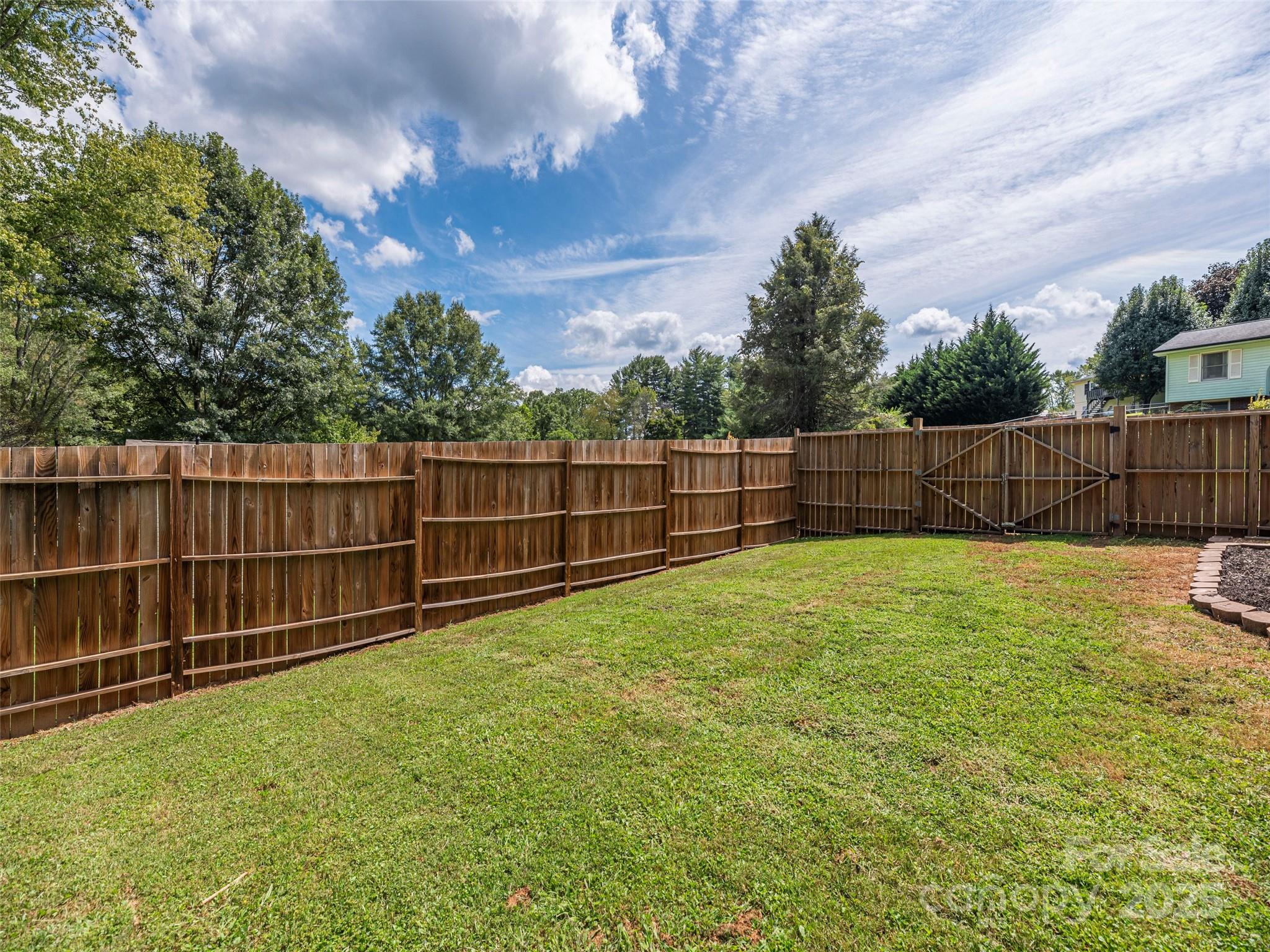 93 Cresthaven Drive Clyde, NC 28721 - Photo 26 of 27 a view of a backyard with a large tree and wooden fence