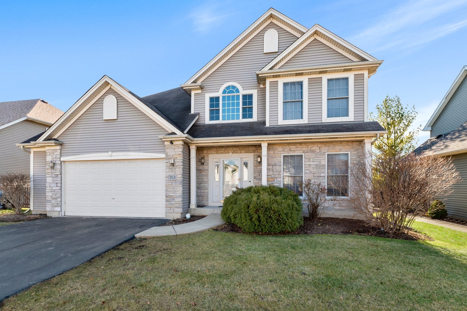 a front view of a house with a yard and garage