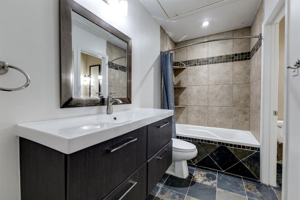 5310 Keller Springs Road, Unit 413 Dallas, TX 75248 - Photo 17 of 20 a bathroom with a sink a toilet a mirror and shower