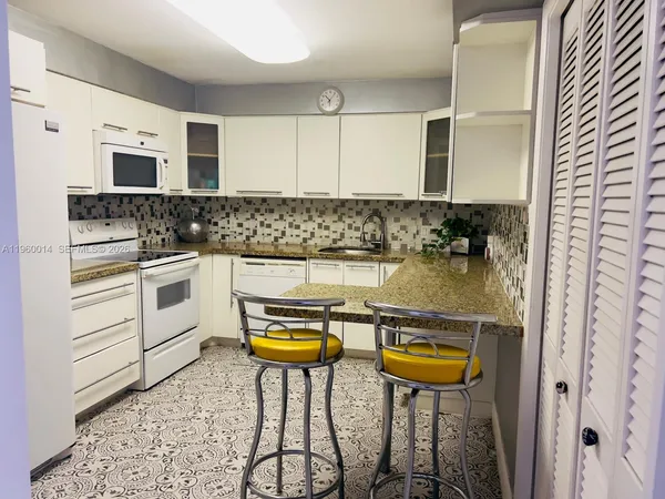 a kitchen with a sink a stove and cabinets