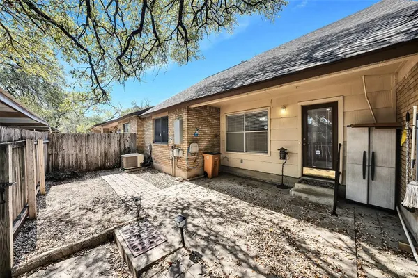 a backyard of a house with wooden fence and a lots of trees
