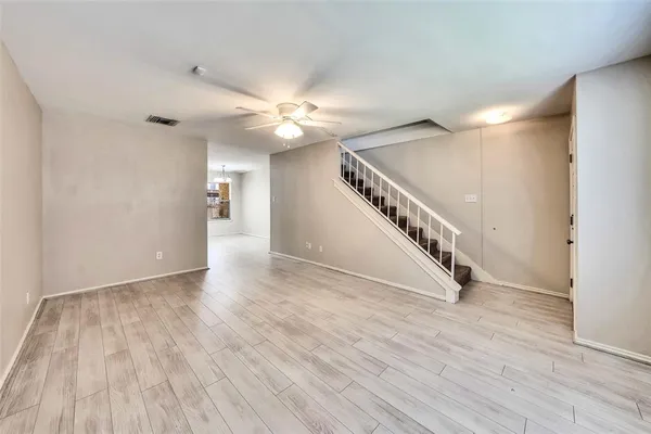 a view of an empty room with a window and wooden floor