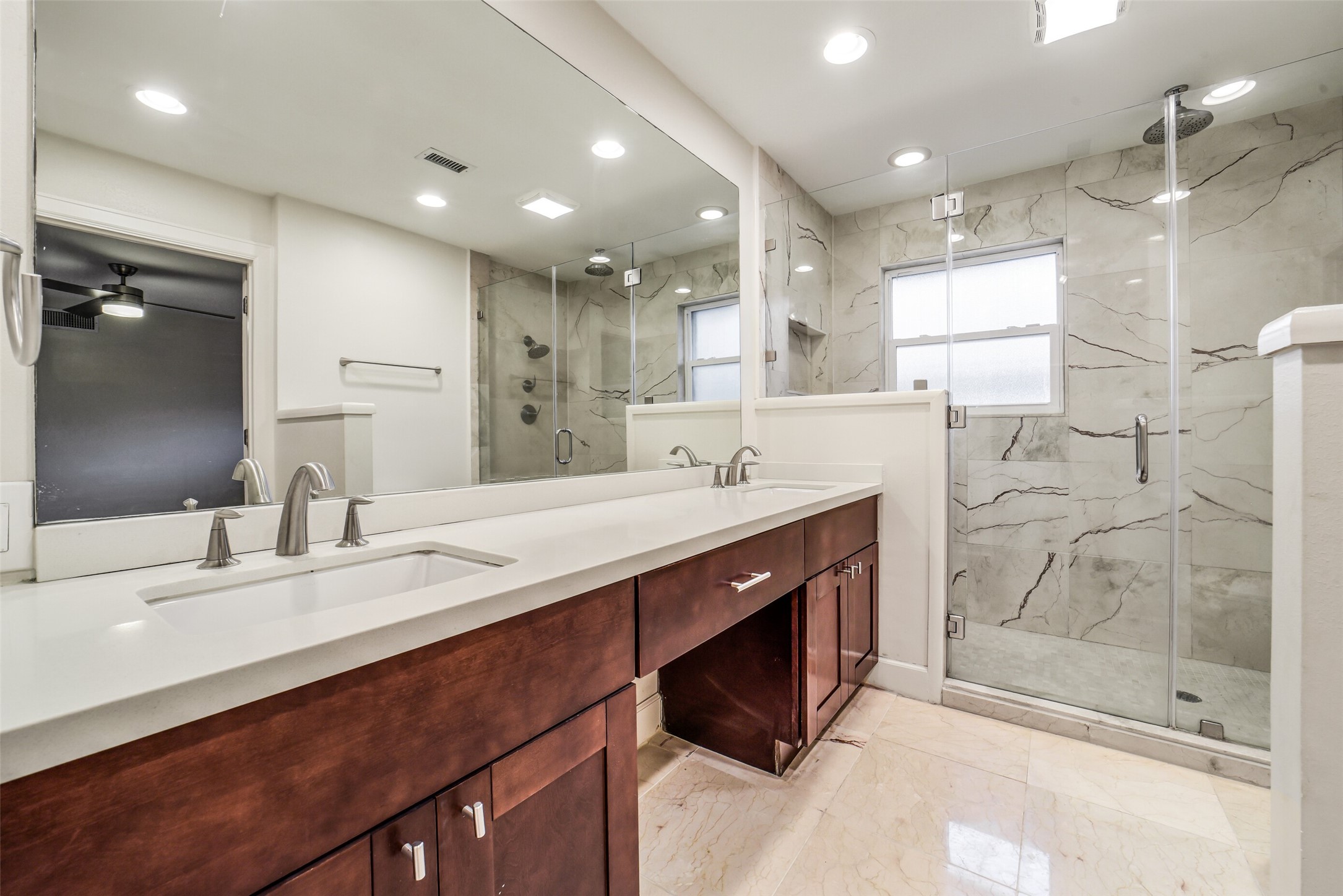 5322 Rutherglenn Drive Houston, TX 77096 - Photo 15 of 30 Spacious, spa-inspired bathroom features a dual-sink vanity w/quartz countertops, rich wood cabinetry, and an oversized walk-in shower w/designer tile surround.