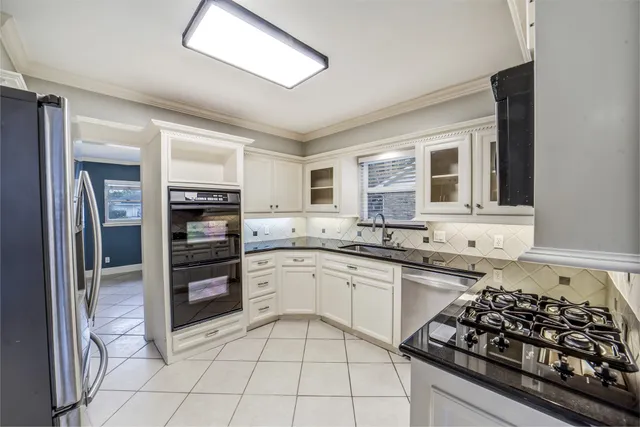 a kitchen with stainless steel appliances a sink stove and refrigerator