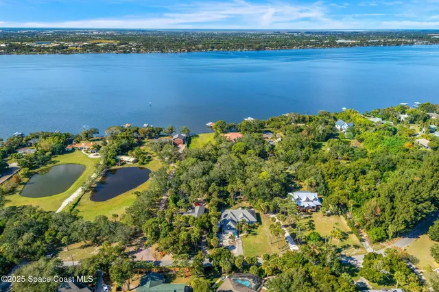 an aerial view of a houses with a lake view