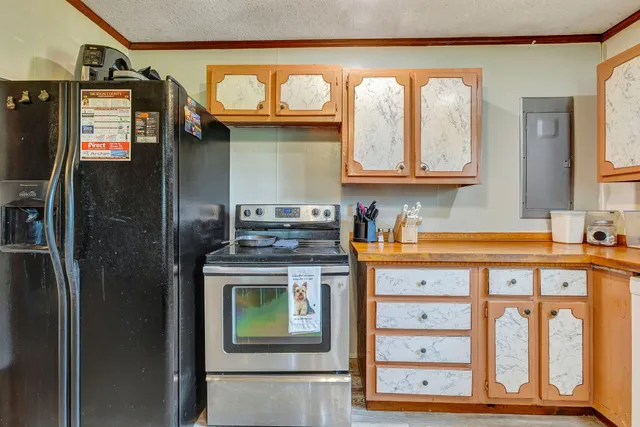 a kitchen with stainless steel appliances granite countertop a refrigerator a stove and a sink