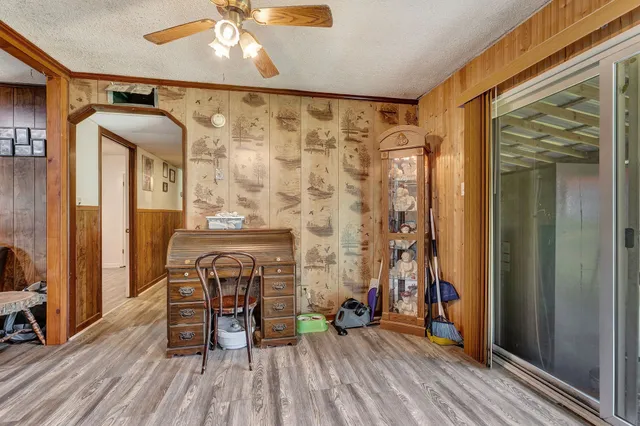 a view of a hallway with wooden floor and furniture