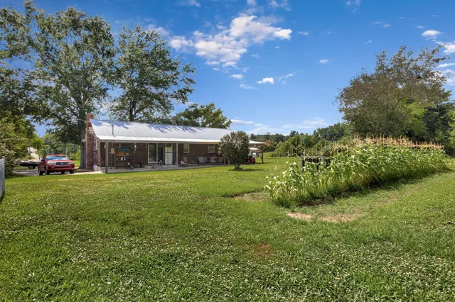a view of a patio with table and chairs and a big yard