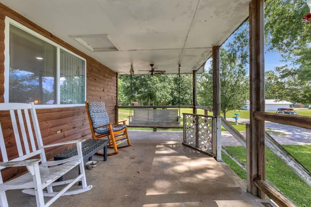 a view of a porch with chairs and backyard
