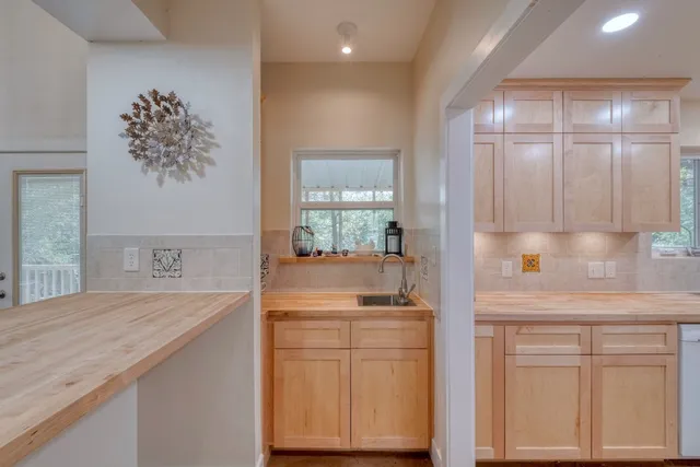 a kitchen with white cabinets and sink
