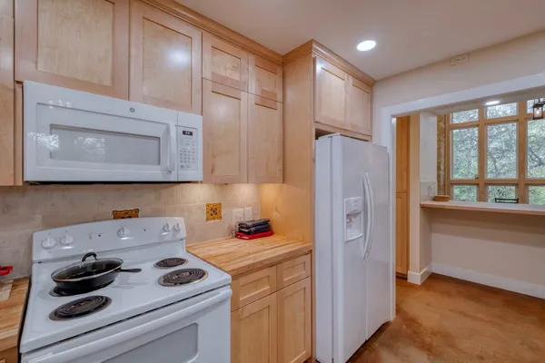 a kitchen with a refrigerator stove and white cabinets