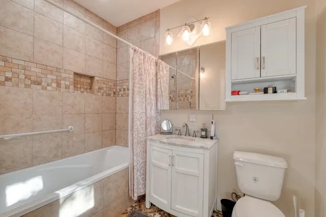 a bathroom with a sink toilet vanity and bathtub