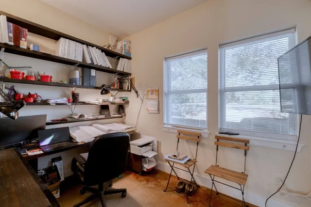 a view of a workspace with furniture and a window