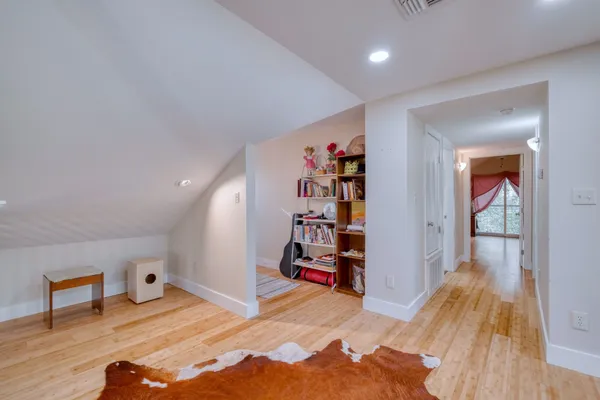 a spacious bedroom with a bed and wooden floor