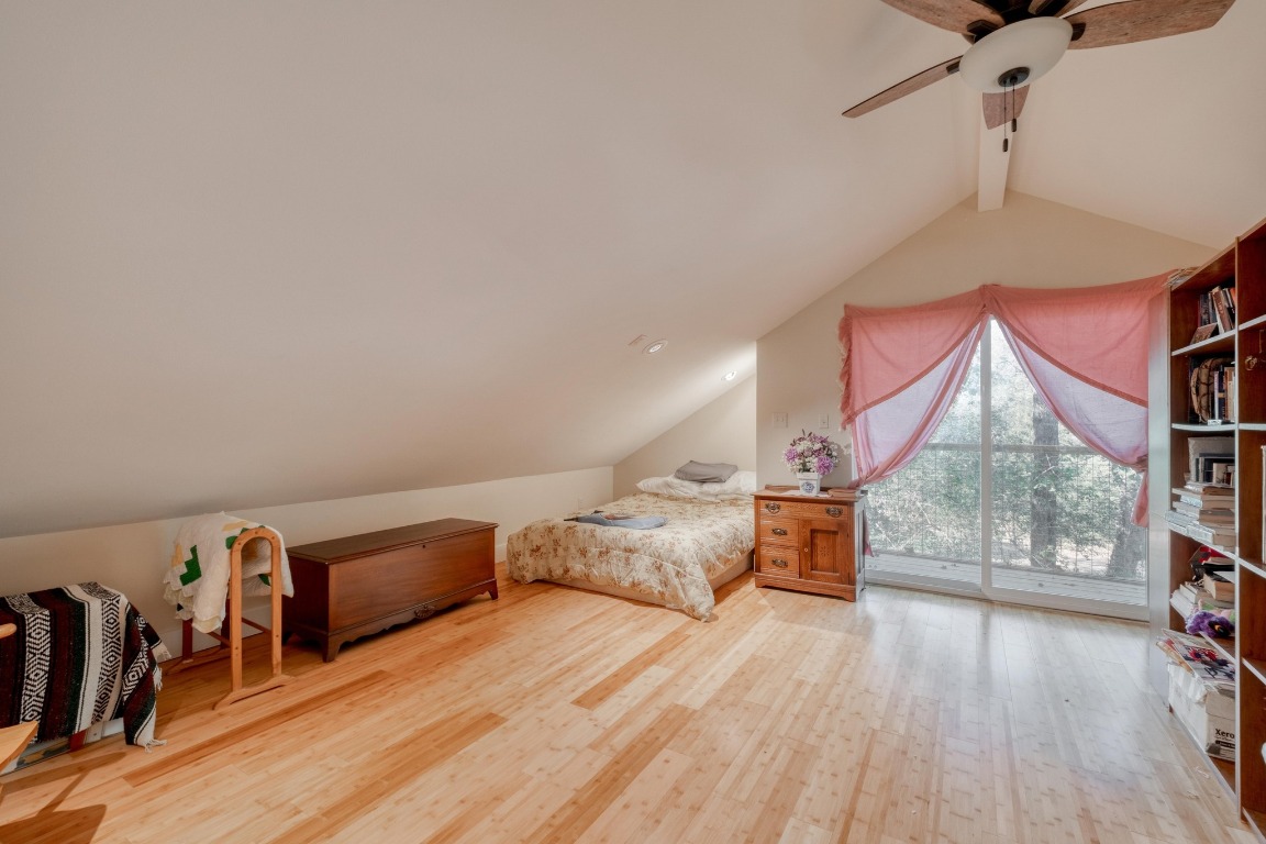 123 Bowie Trail Luling, TX 78648 - Photo 29 of 39 a spacious bedroom with a bed and wooden floor