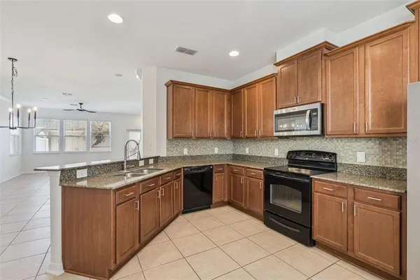 a kitchen with stainless steel appliances granite countertop a stove top oven a sink dishwasher and a microwave oven on the blue kitchen countertops
