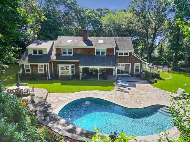an aerial view of a house with swimming pool having outdoor seating