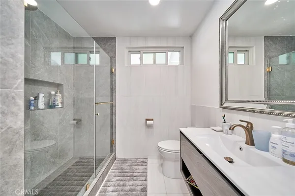 a bathroom with a double vanity sink toilet and shower