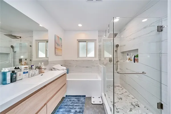 a bathroom with a tub sink and mirror